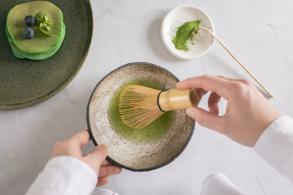Batiendo té matcha con un chasen o batidor de bambú